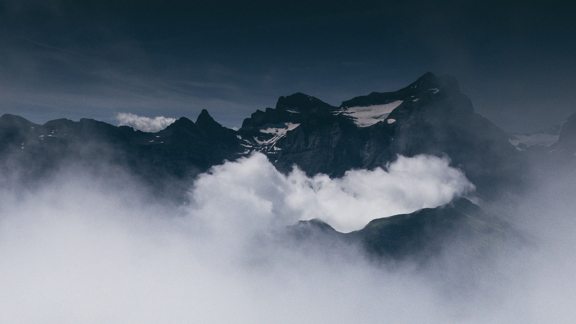 Mountain peaks shrouded in clouds HD Wallpaper