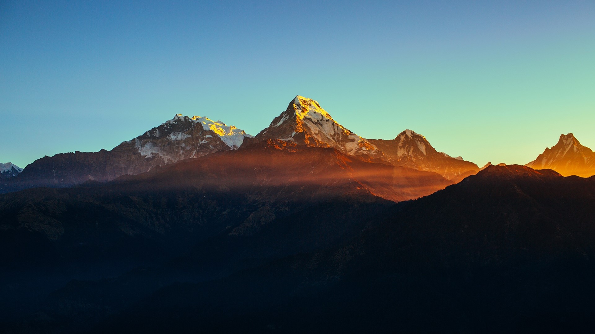 Mountain peaks at sunset with orange mist HD Wallpaper