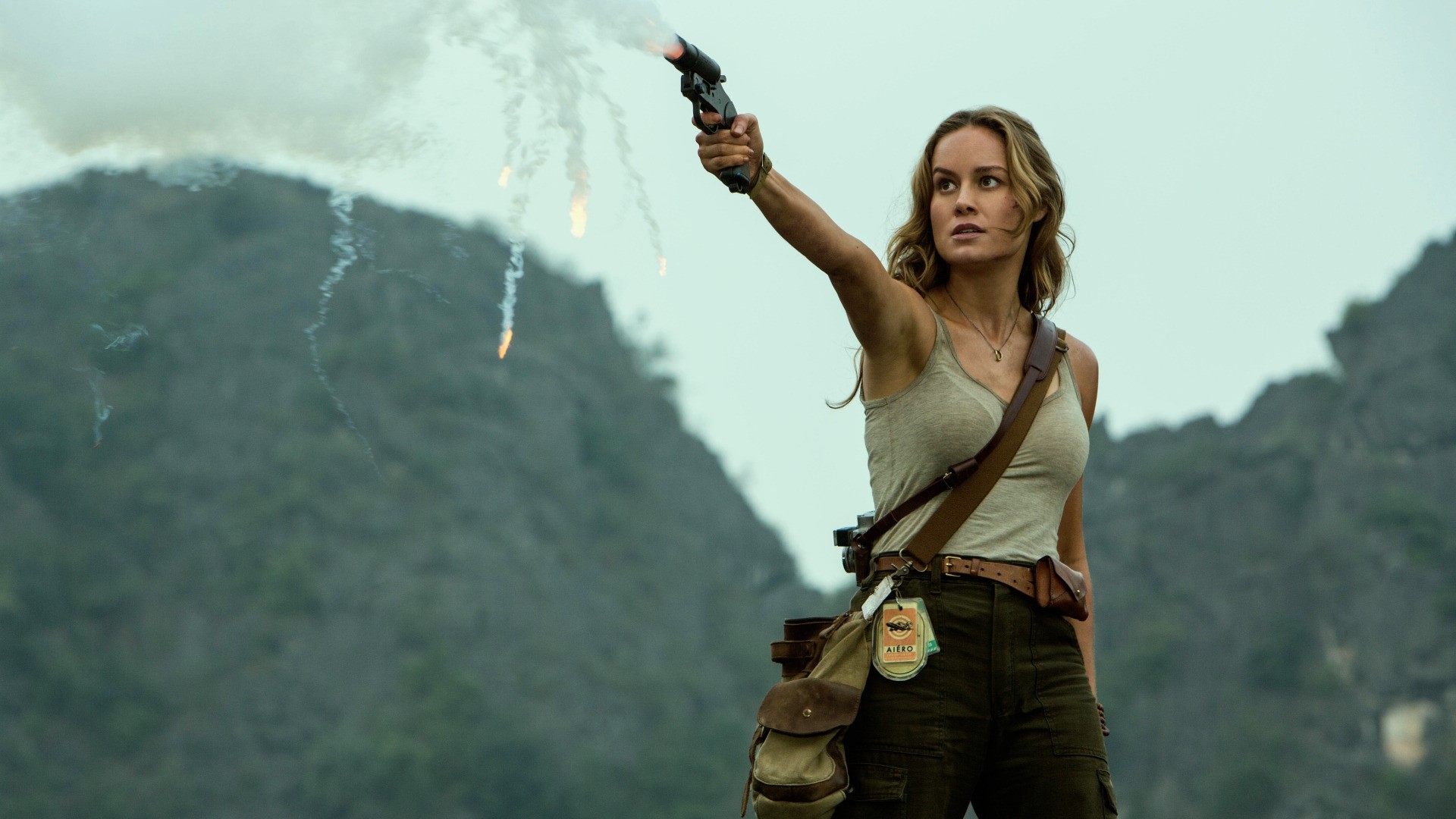 Woman firing flare gun in mountainous terrain HD Wallpaper