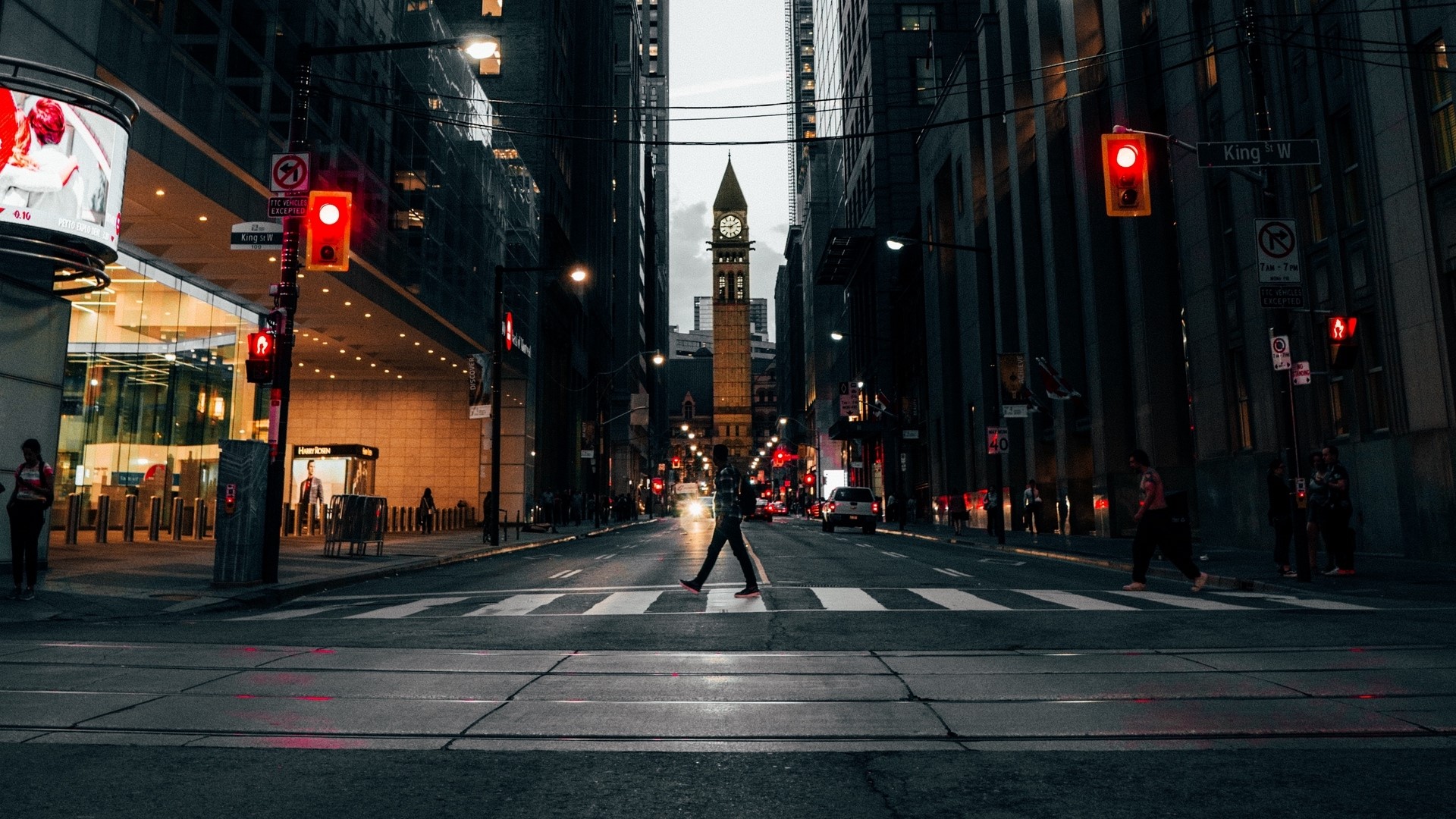 Person crossing street in city with clock tower HD Wallpaper