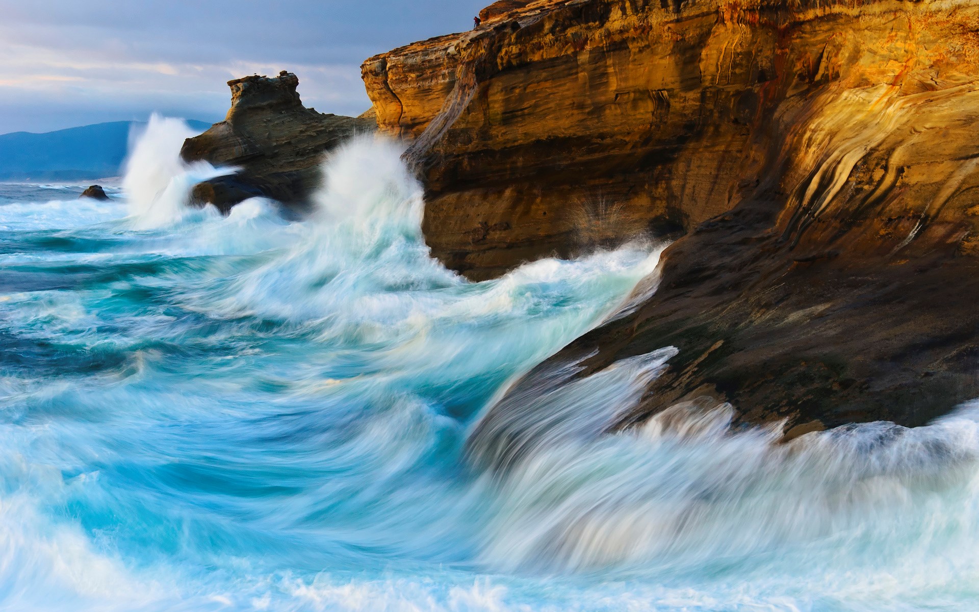 Waves crashing against rocky cliffs at sunset HD Wallpaper