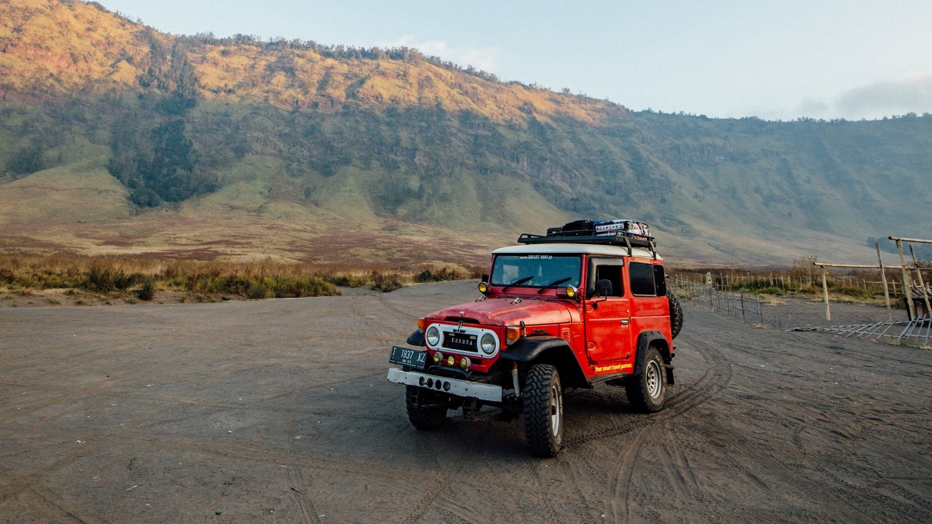 Red Toyota Land Cruiser FJ40 in a mountainous landscape HD Wallpaper