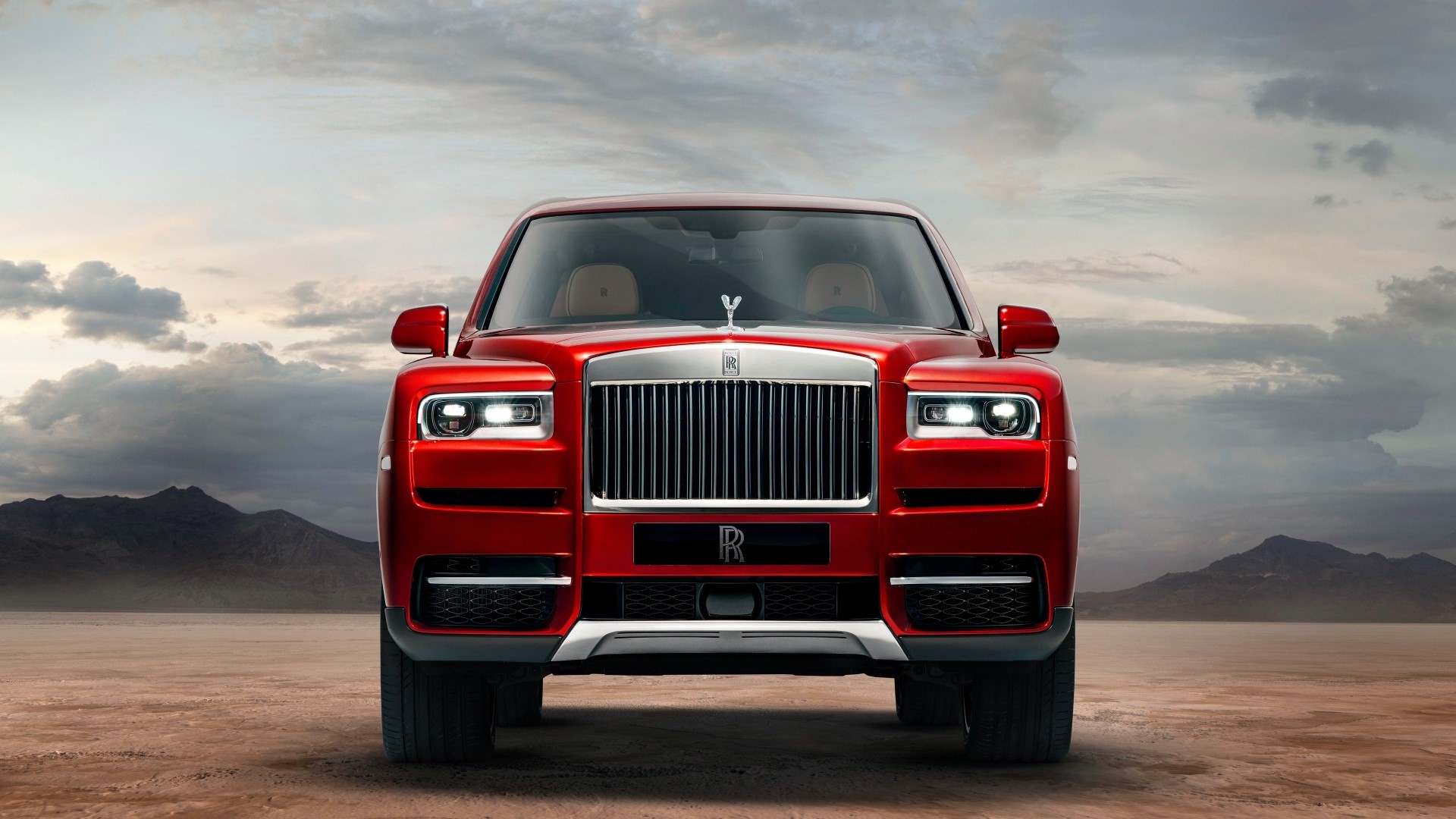 Red Rolls Royce Cullinan in a desert landscape HD Wallpaper