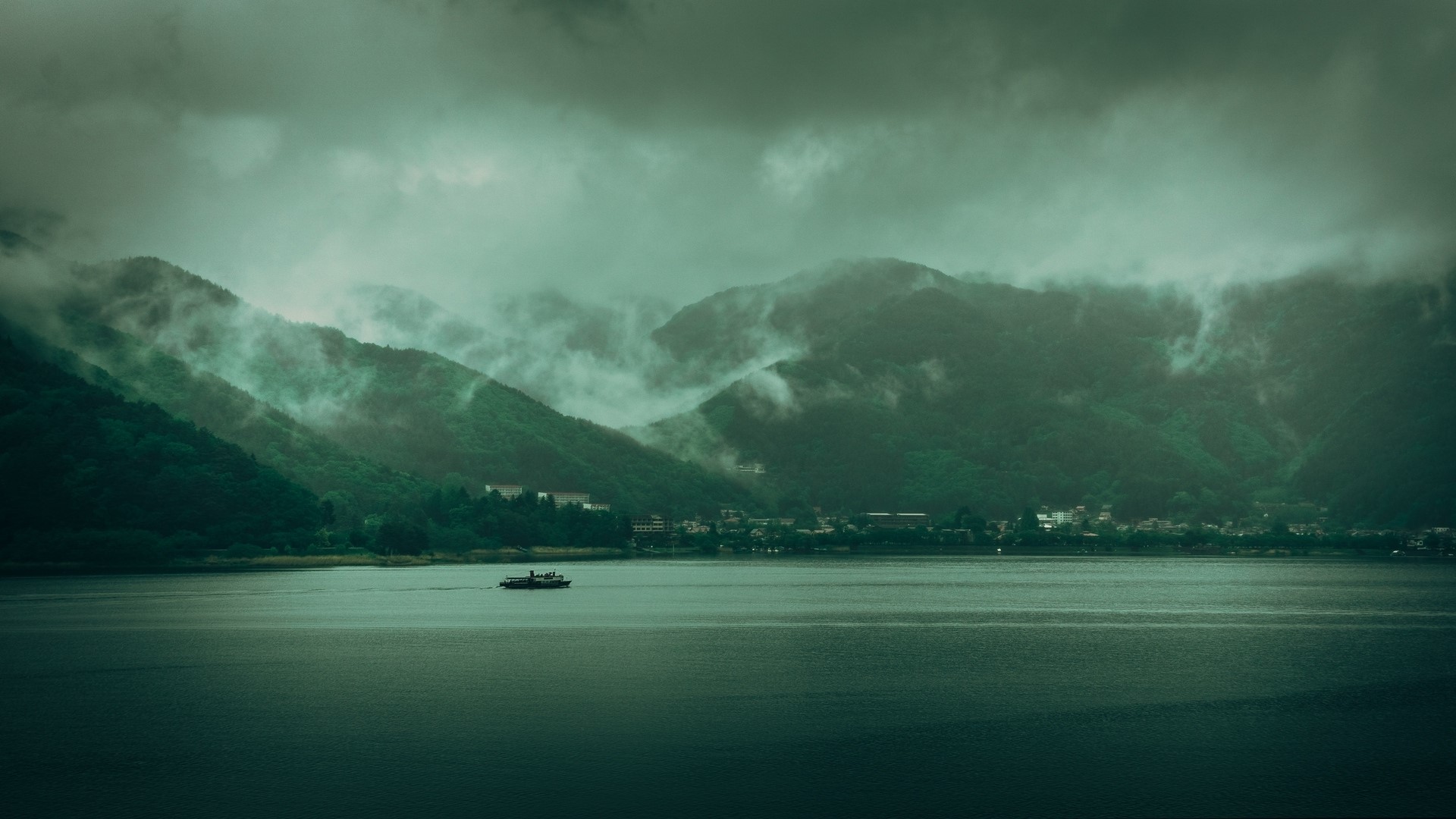 Boat on a lake with misty mountains HD Wallpaper
