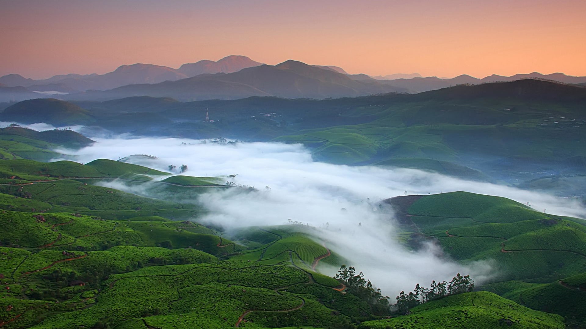Foggy valley with rolling green hills and mountains HD Wallpaper