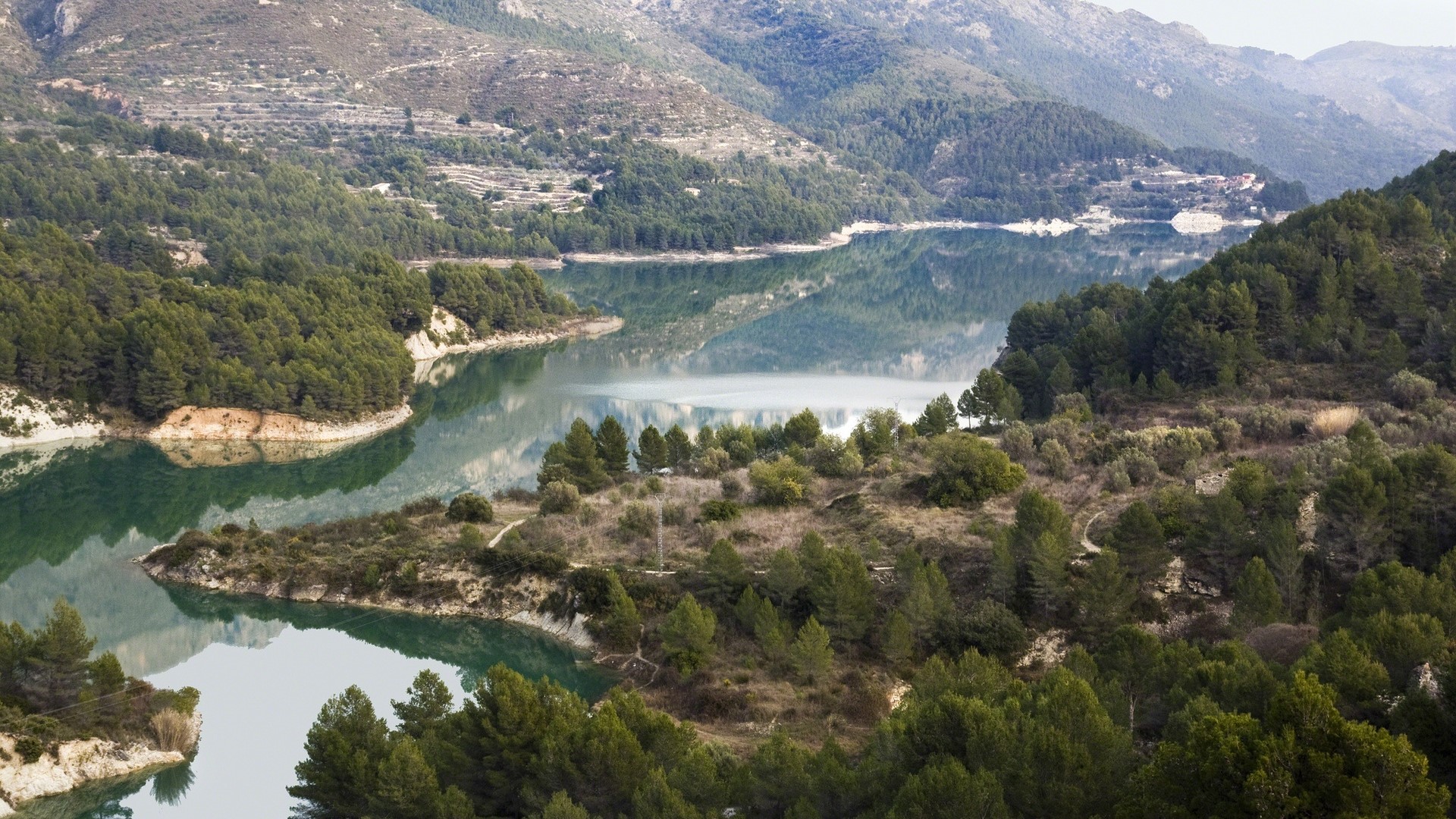 River bend surrounded by forested mountains HD Wallpaper