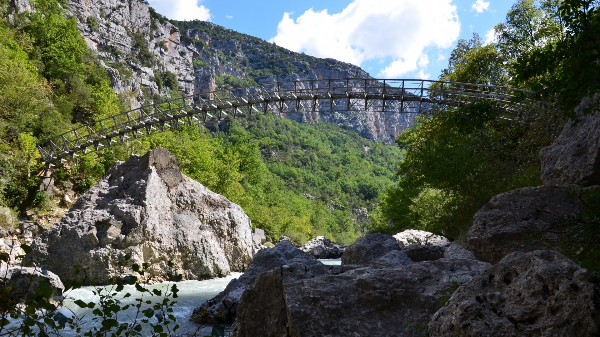 Suspension bridge over a river in a gorge HD Wallpaper