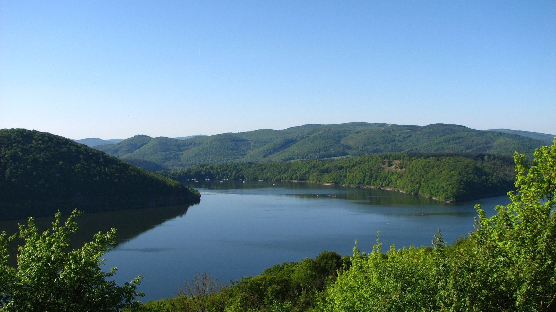 Lake and green hills under a clear blue sky HD Wallpaper