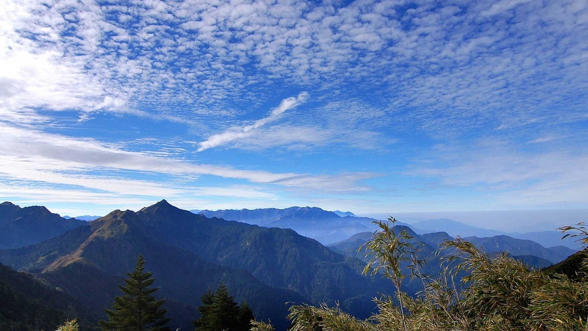 Mountains under a blue sky with scattered clouds HD Wallpaper