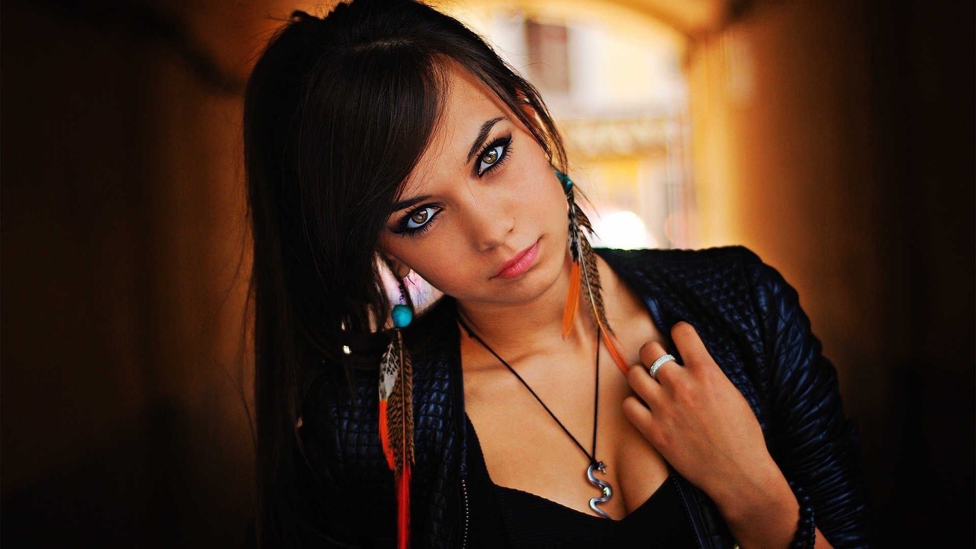 Young woman with feather earrings and snake necklace HD Wallpaper
