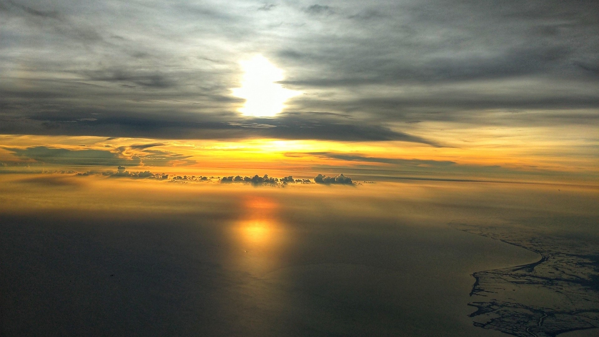 Sunset over the ocean with clouds and land HD Wallpaper