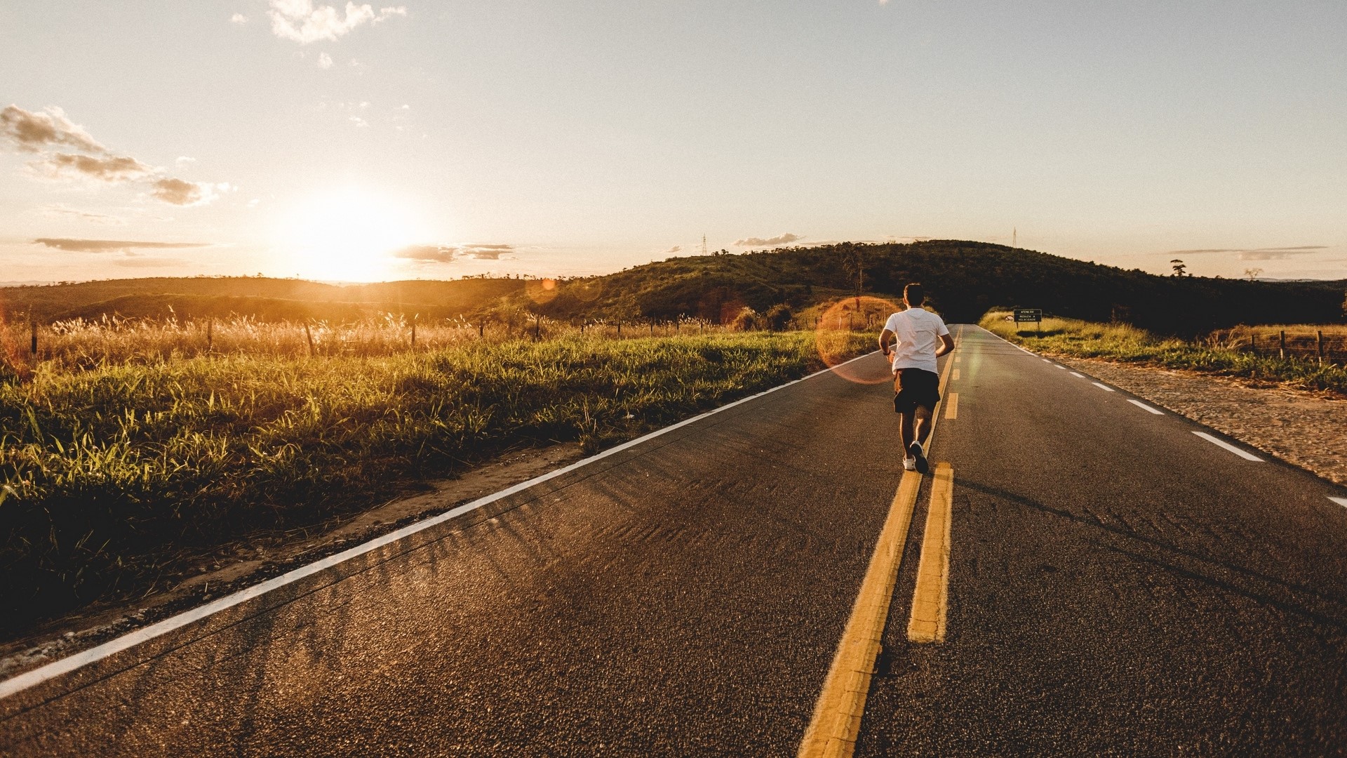Man running on a road at sunset HD Wallpaper