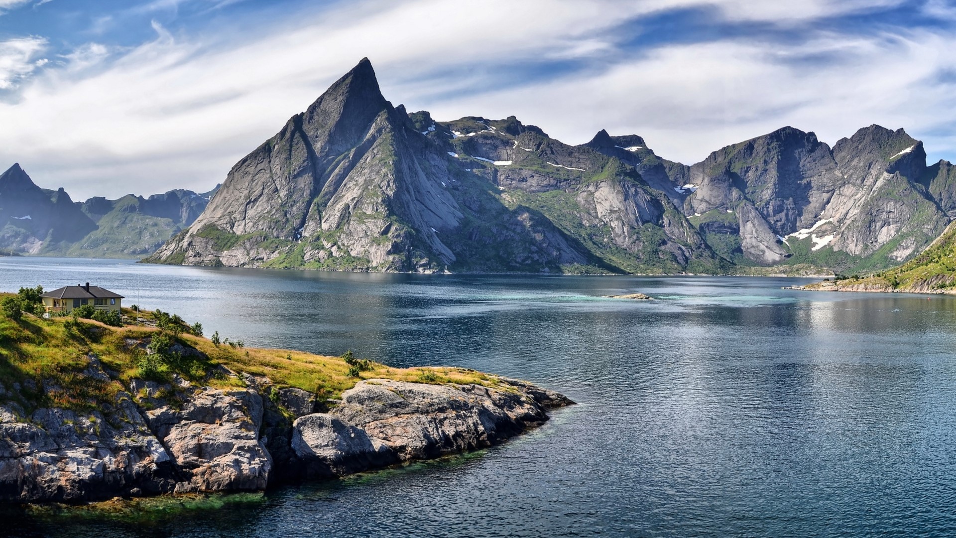 House on the bank of a fjord with mountains HD Wallpaper
