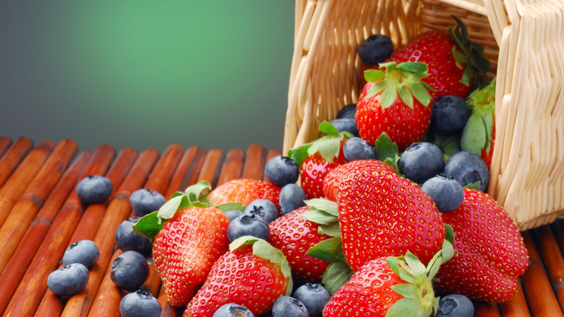 Strawberries and blueberries spilling from a basket HD Wallpaper