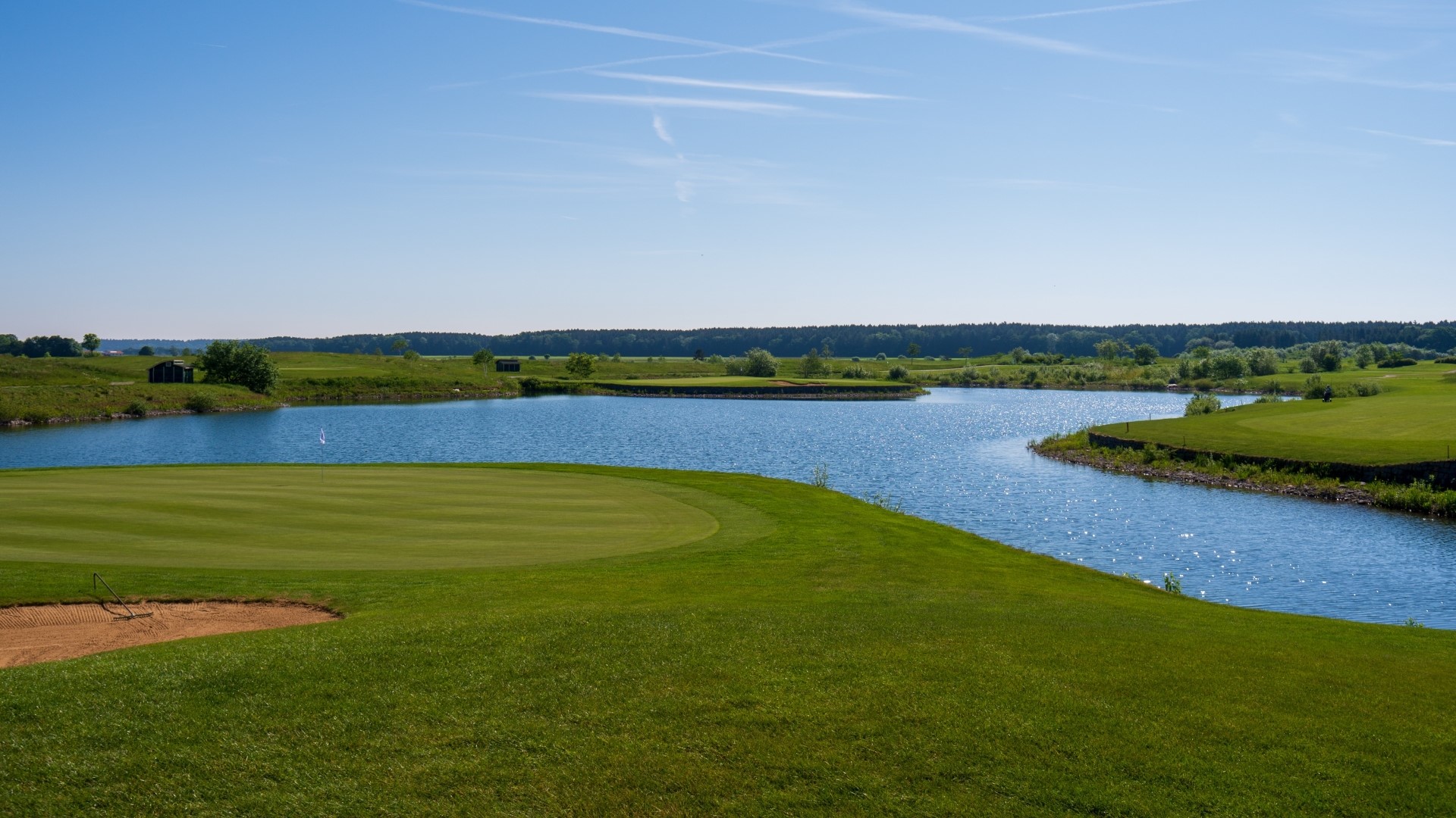Golf course with a lake and blue sky HD Wallpaper