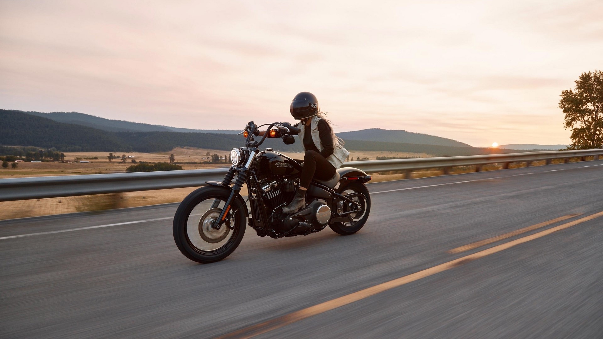Woman riding a Harley-Davidson motorcycle at sunset HD Wallpaper