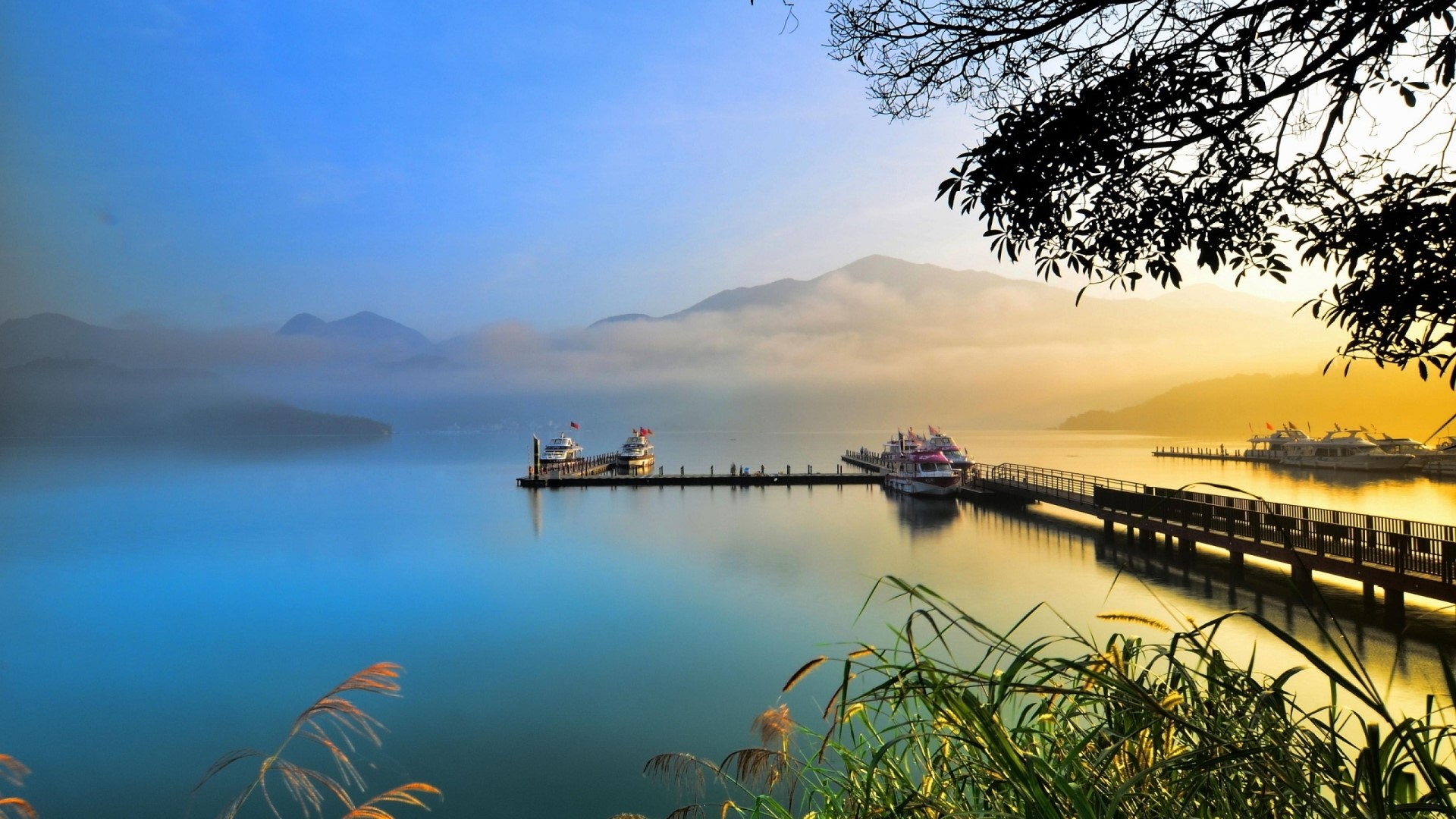 Boats docked at a pier on a misty lake at sunrise HD Wallpaper