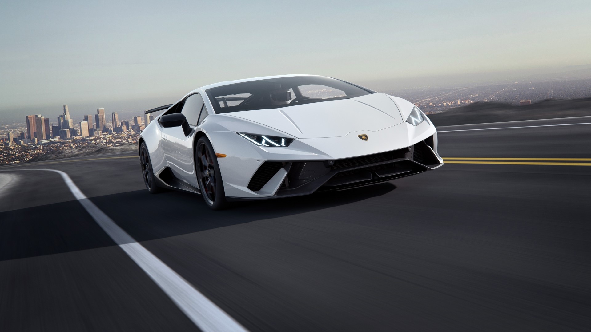 White Lamborghini Driving on a Road with Cityscape HD Wallpaper