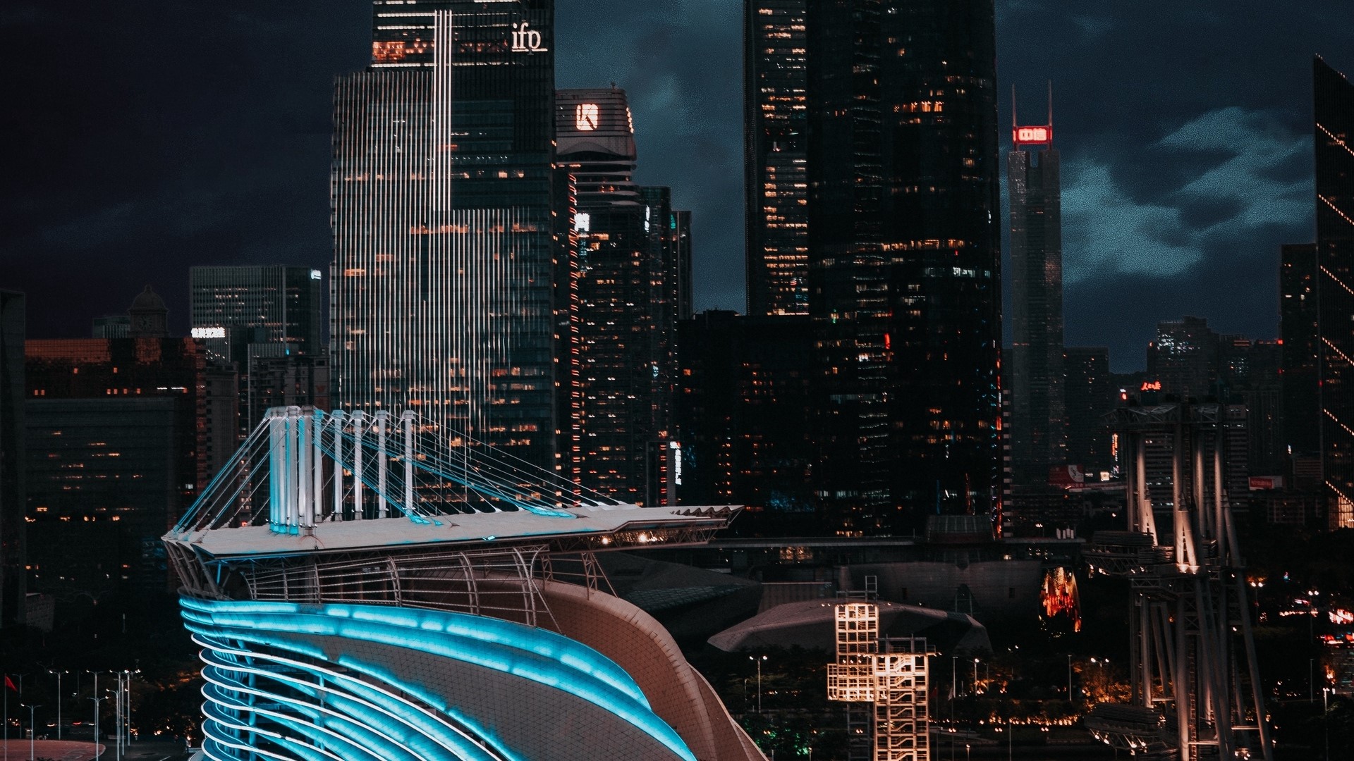 Night city skyline with illuminated buildings and bridge HD Wallpaper