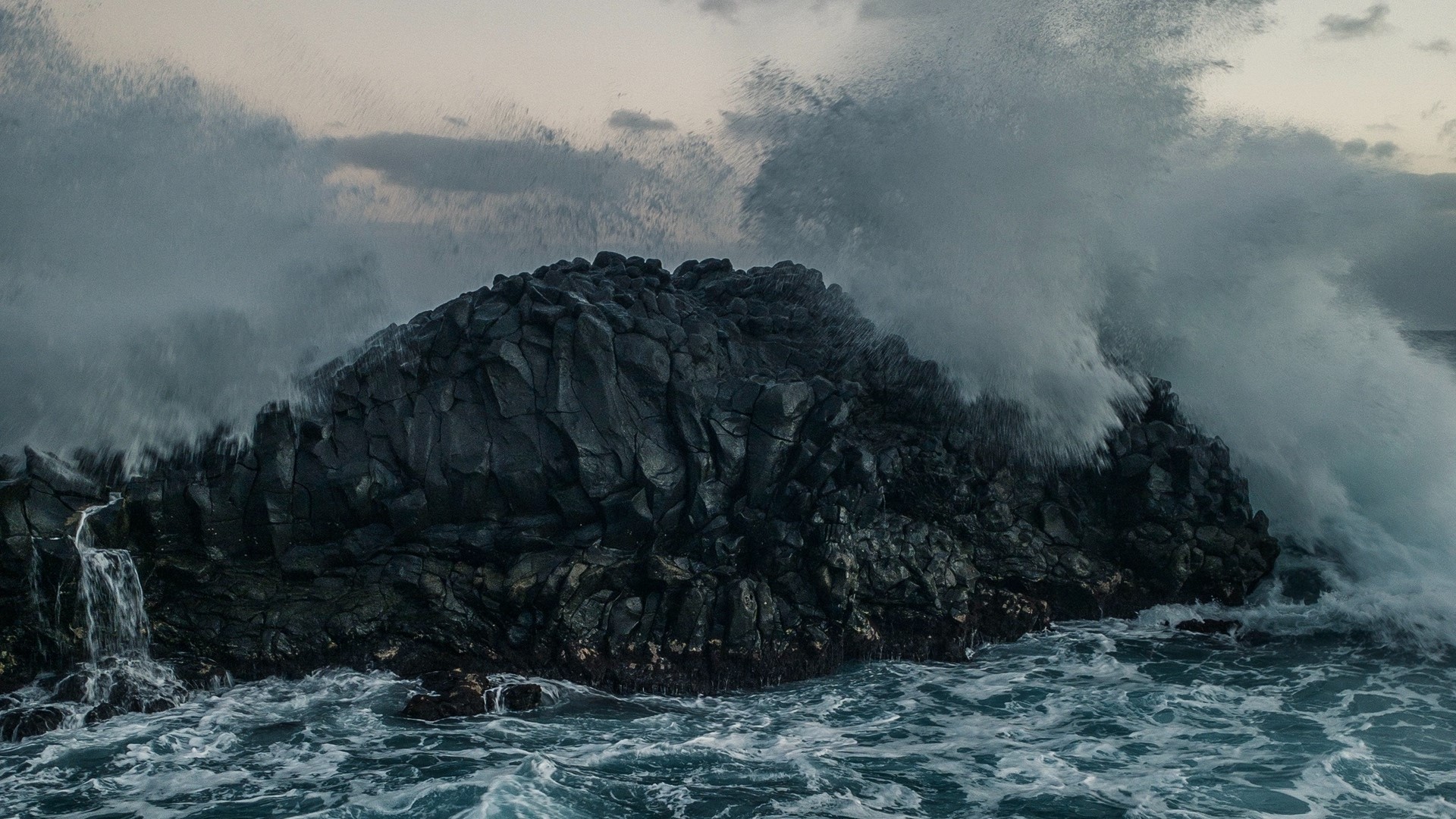 Waves crashing on dark volcanic rocks HD Wallpaper
