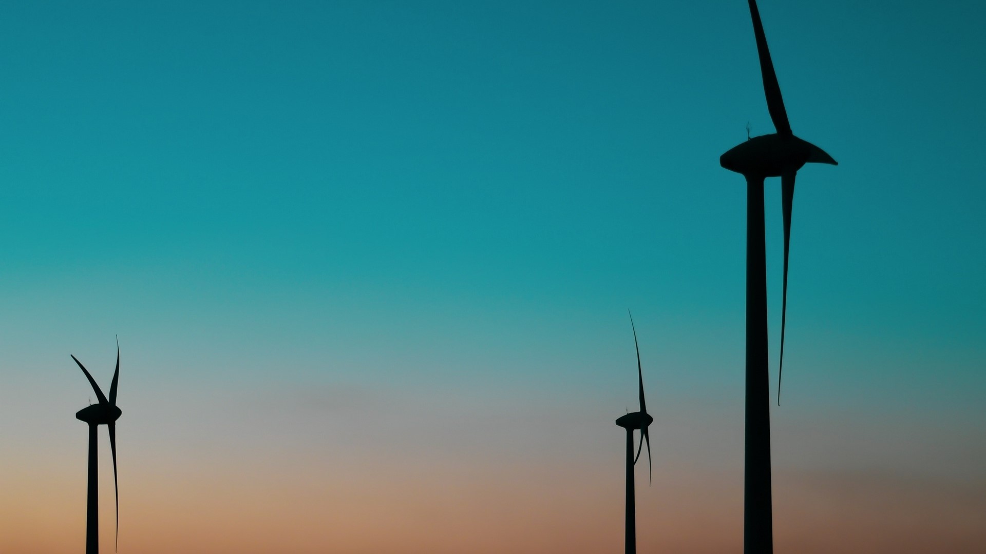 Wind turbines silhouetted against a gradient sky HD Wallpaper