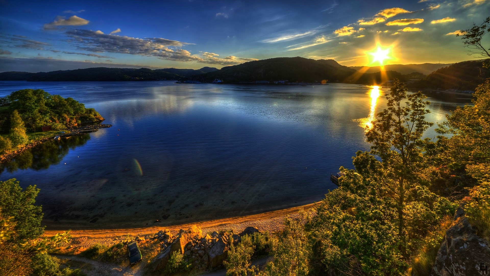 Sunset over a calm lake with trees and mountains HD Wallpaper