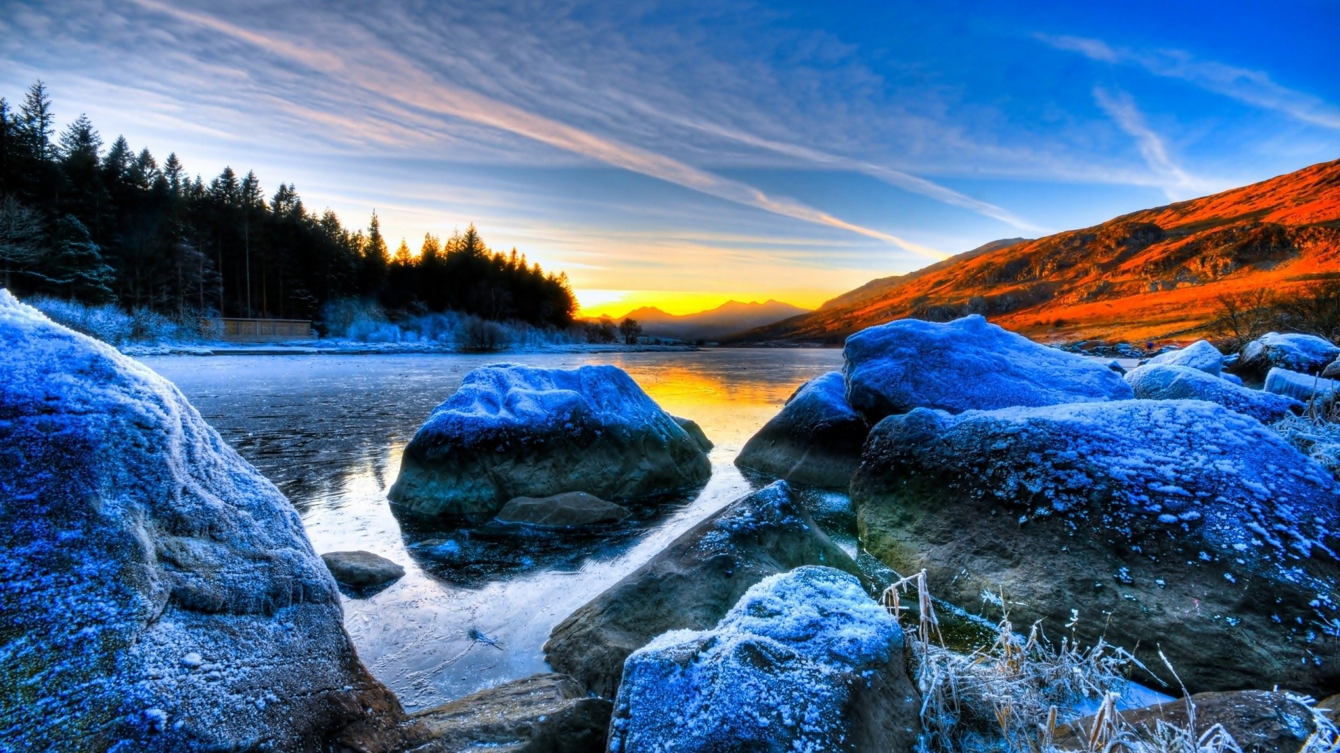 Frozen rocks by a lake at sunset HD Wallpaper