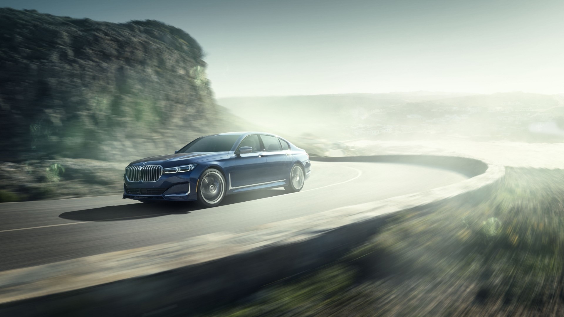 Blue BMW Alpina B7 driving on a winding road HD Wallpaper