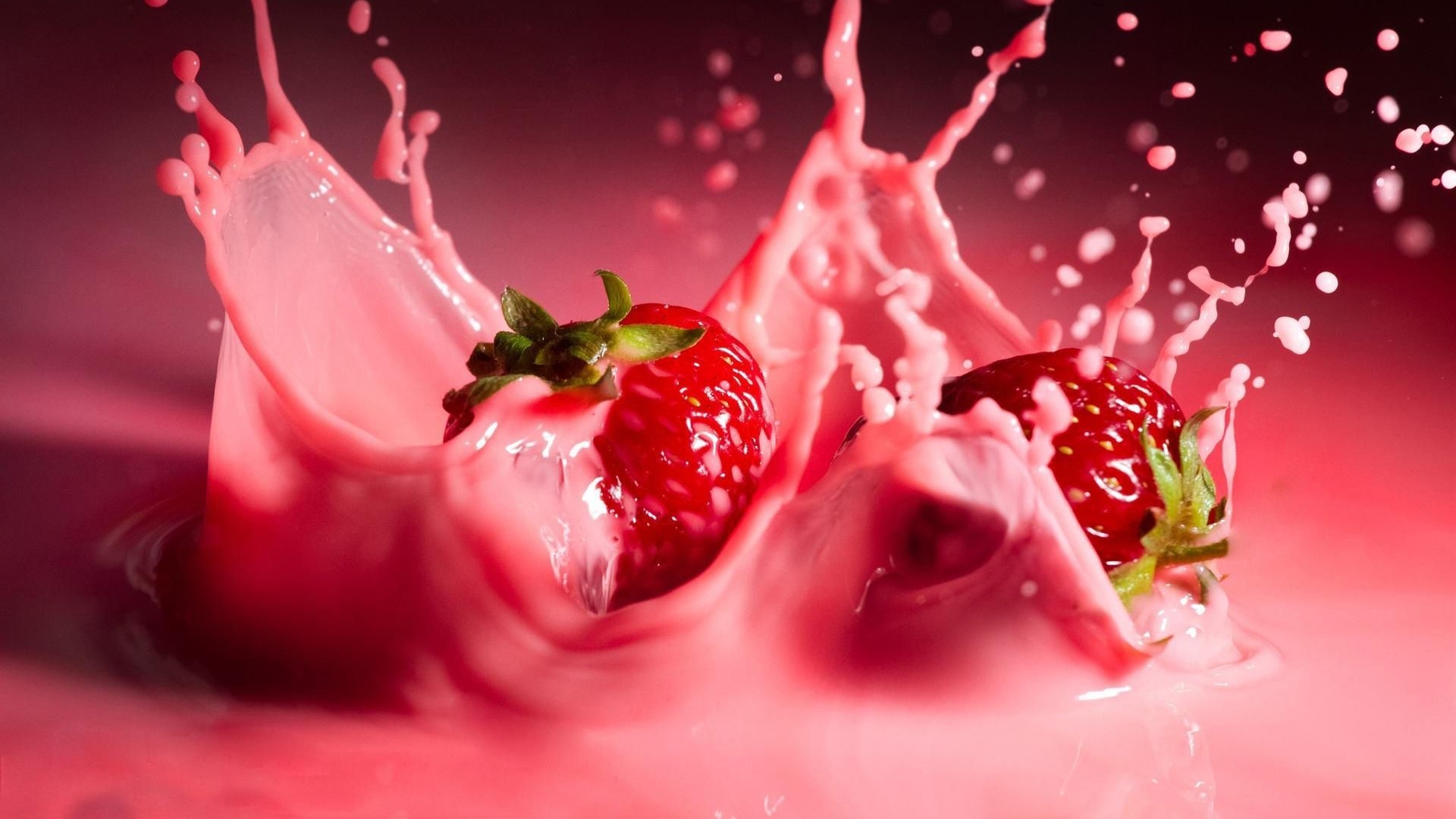 Strawberries splashing in pink liquid HD Wallpaper