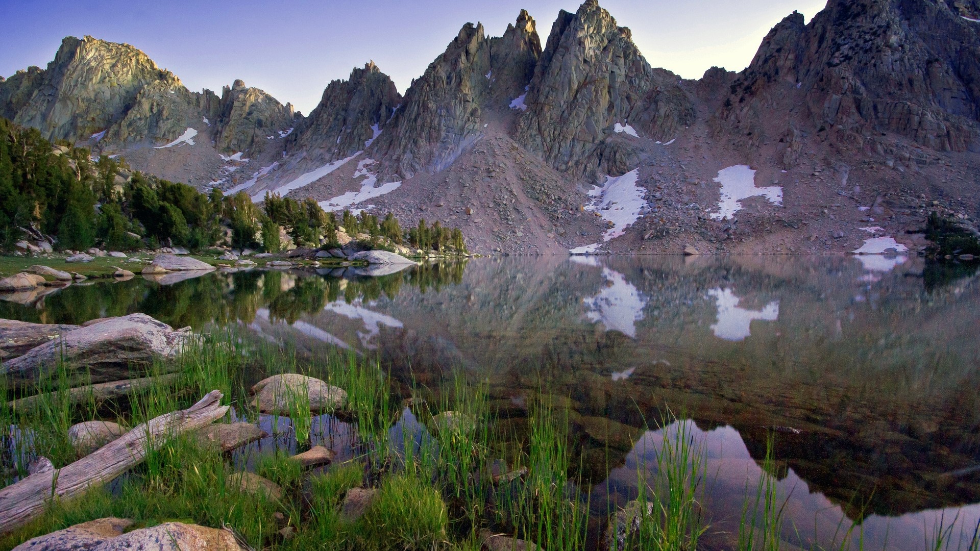 Mountain lake with reflections and grass in foreground HD Wallpaper