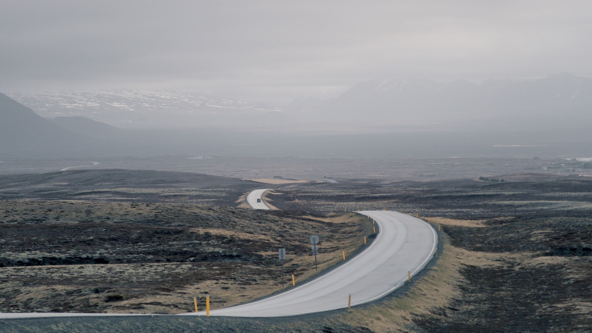 Curving road through a desolate landscape HD Wallpaper