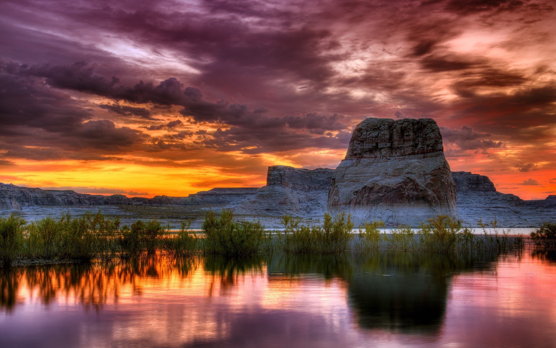 Dramatic sunset over a lake with rock formations HD Wallpaper