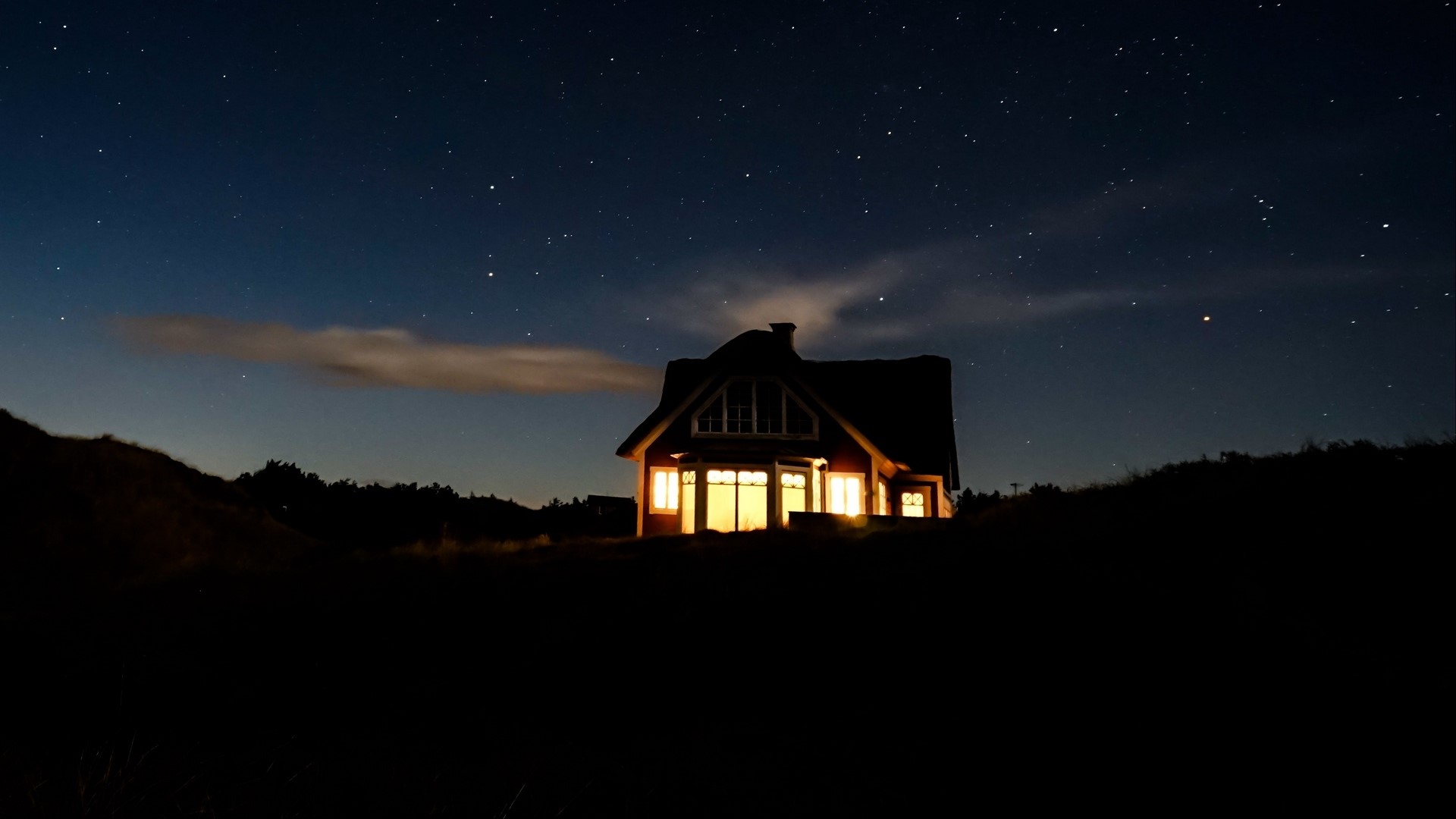 House illuminated at night under a starry sky HD Wallpaper