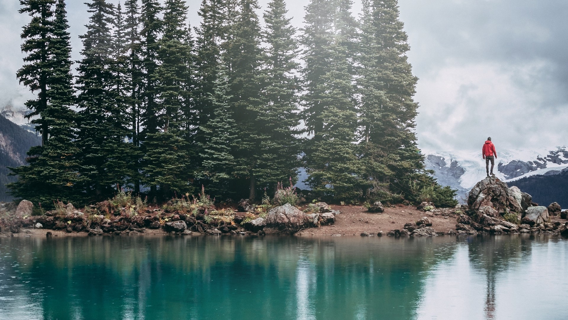 Man in red jacket on rock overlooking lake and mountains HD Wallpaper