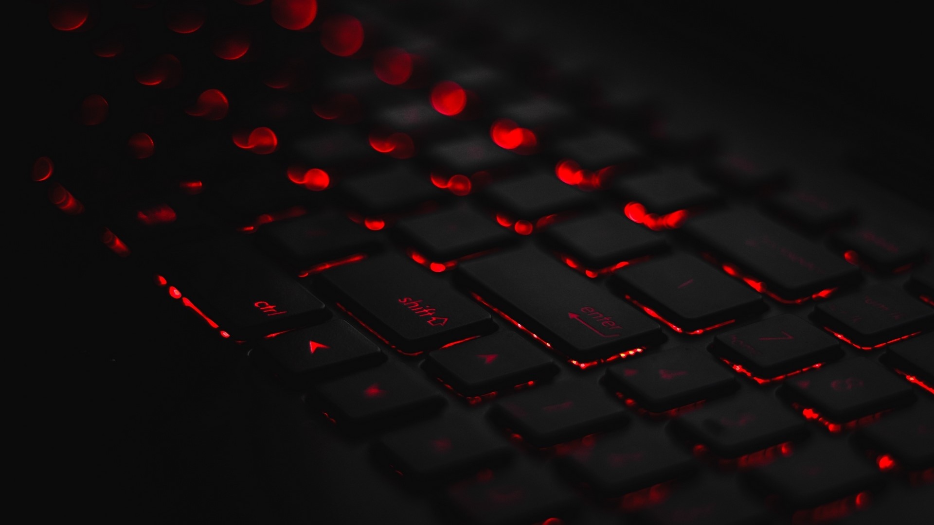 Close-up of a black keyboard with red backlighting HD Wallpaper