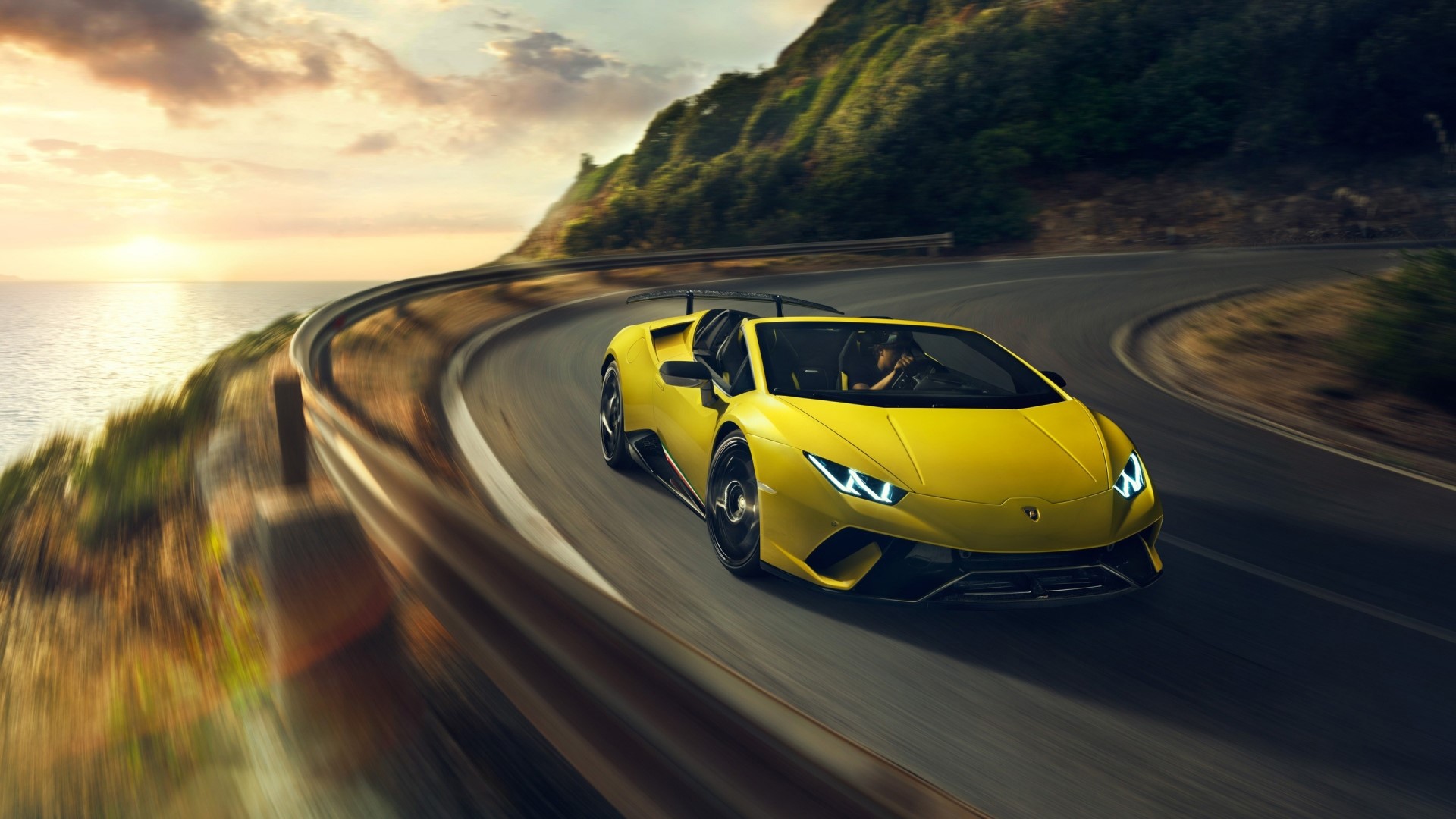 Yellow Lamborghini Huracan driving on coastal road HD Wallpaper