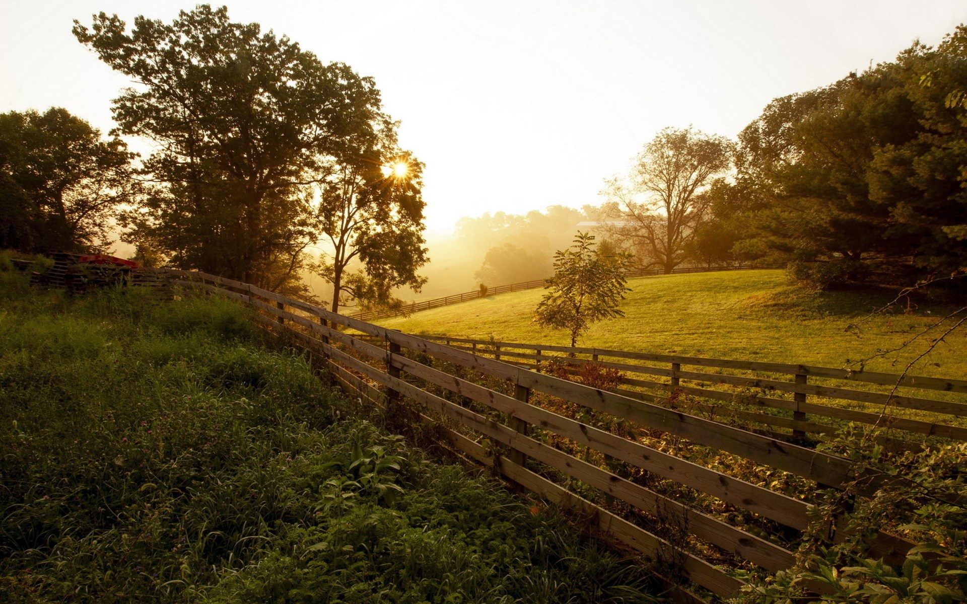 Sunrise over a wooden fence and rolling hills HD Wallpaper