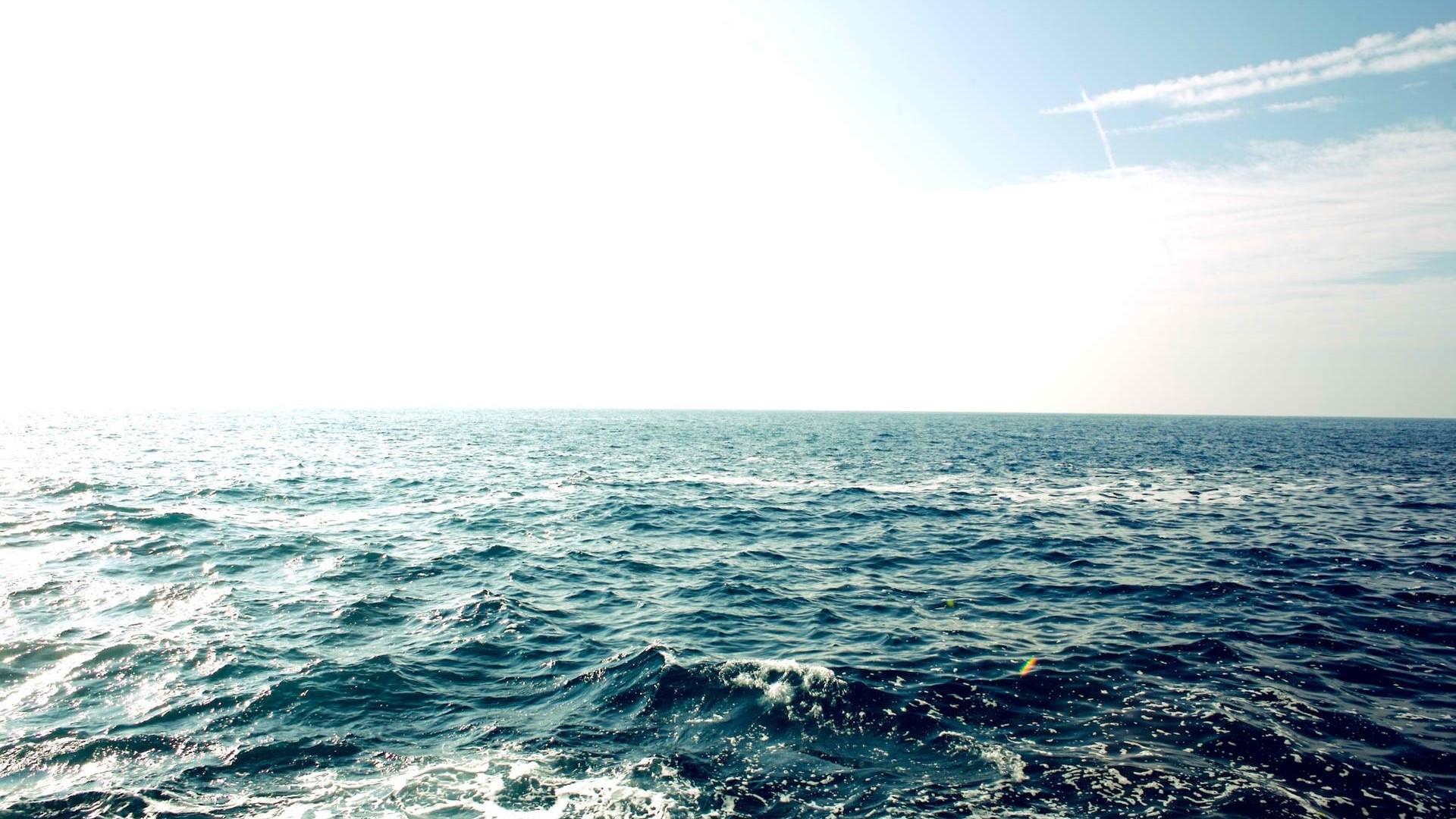 Ocean waves under a bright sky HD Wallpaper