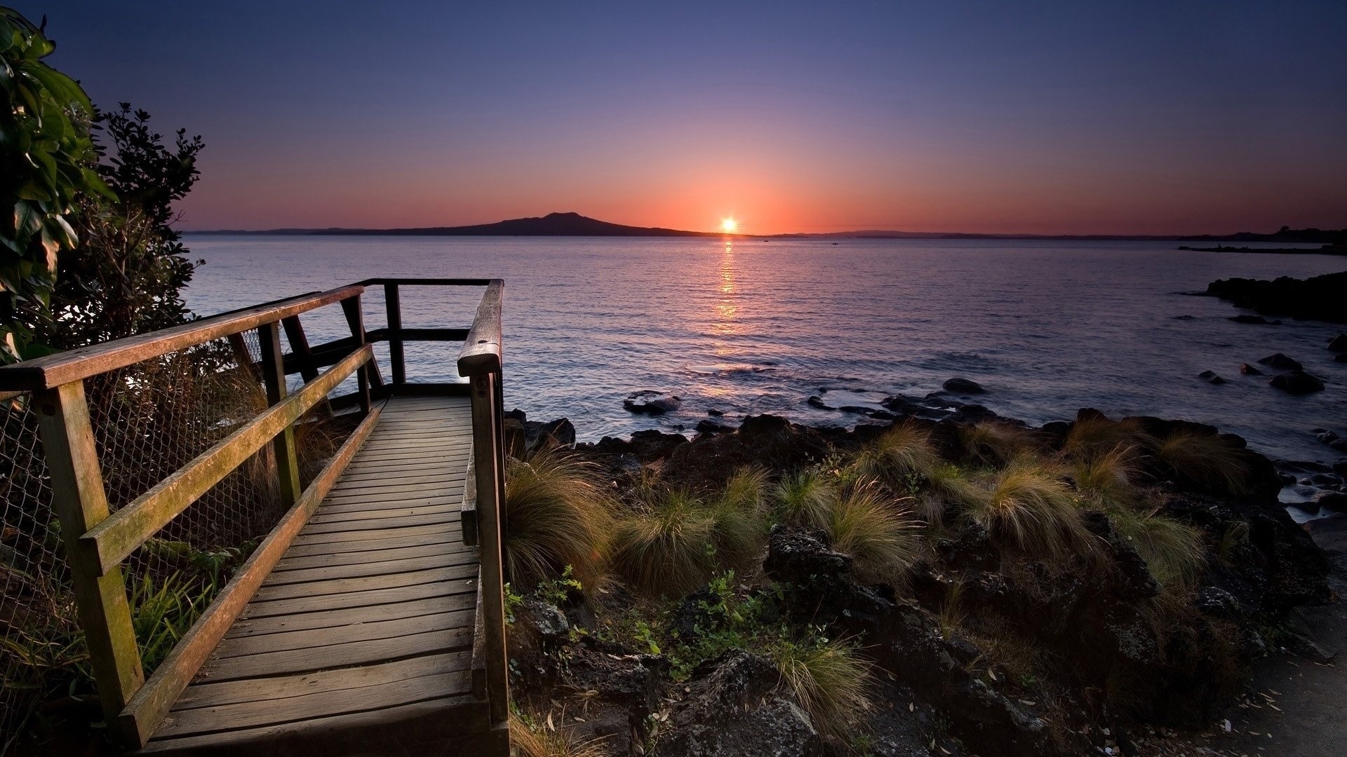 Wooden walkway overlooking ocean at sunset HD Wallpaper