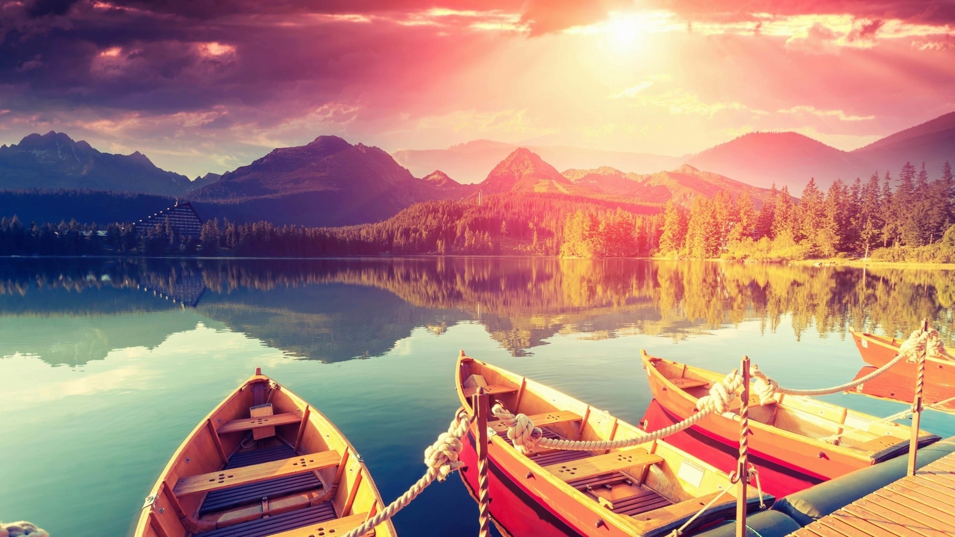 Boats docked at a pier on a lake with mountains HD Wallpaper