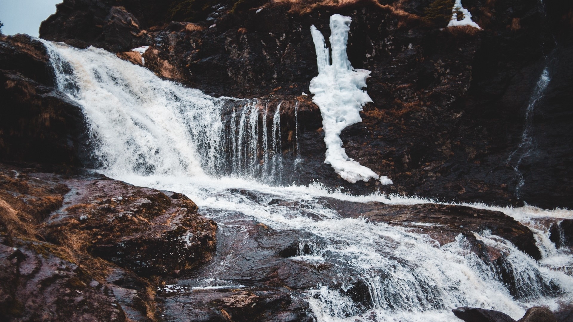 Waterfall cascading over rocks with ice HD Wallpaper