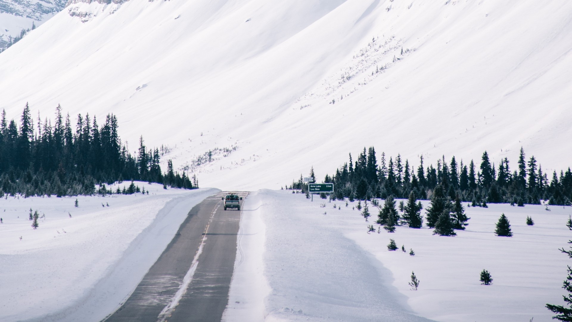 Van driving on a snowy mountain road HD Wallpaper