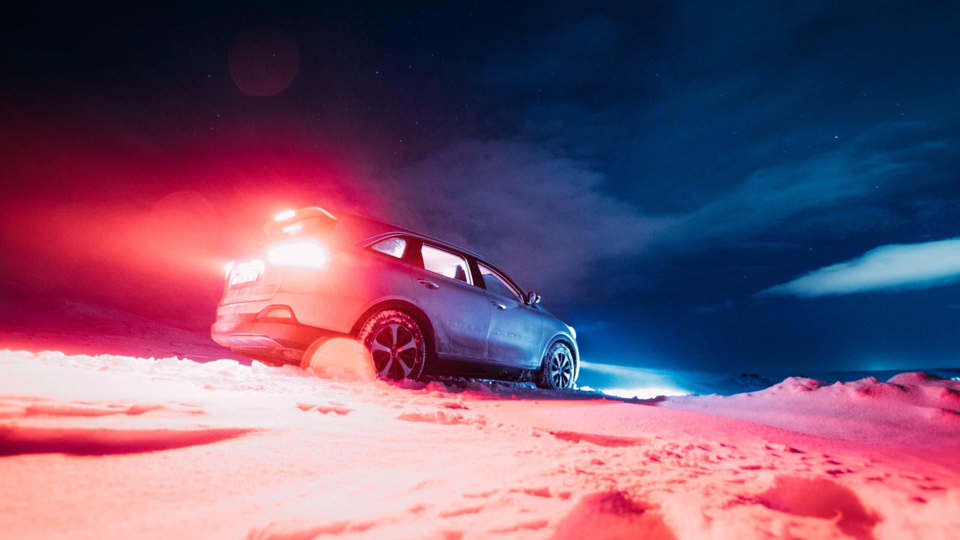 Car in snow at night with red and blue lights HD Wallpaper