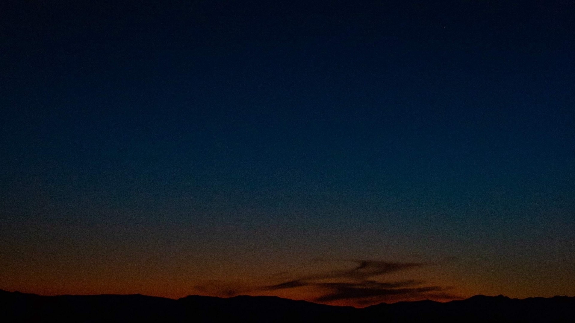 Dark blue night sky over silhouetted mountains HD Wallpaper
