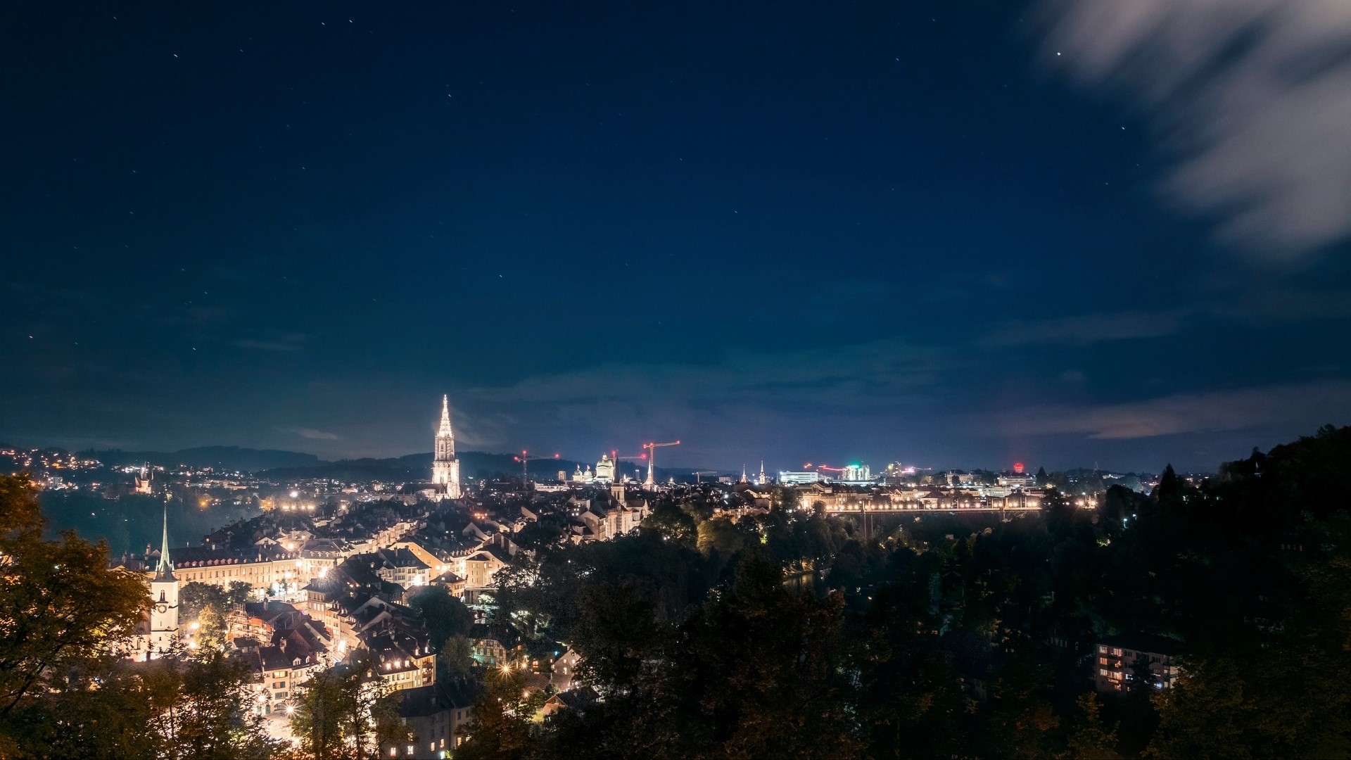 Night view of a city with a prominent church spire HD Wallpaper