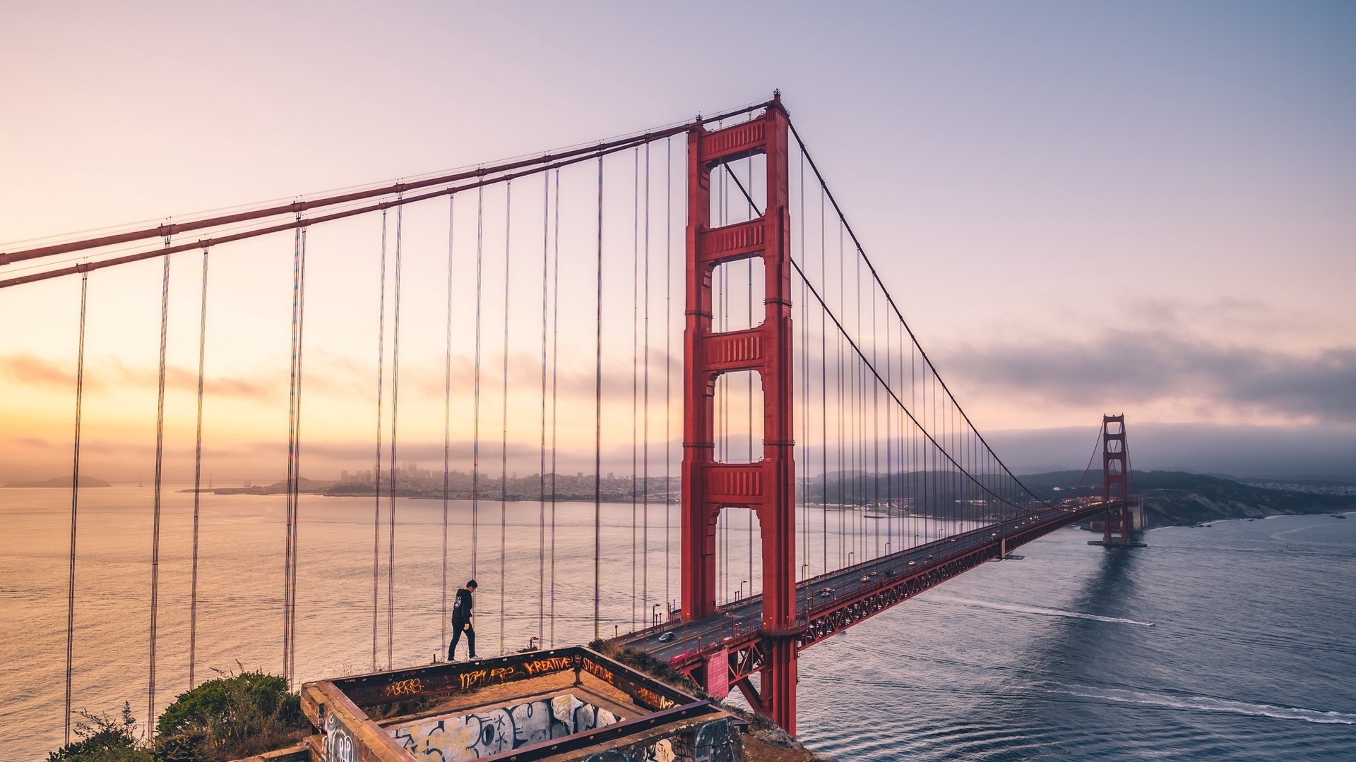 Golden Gate Bridge at sunrise with a person on the edge HD Wallpaper