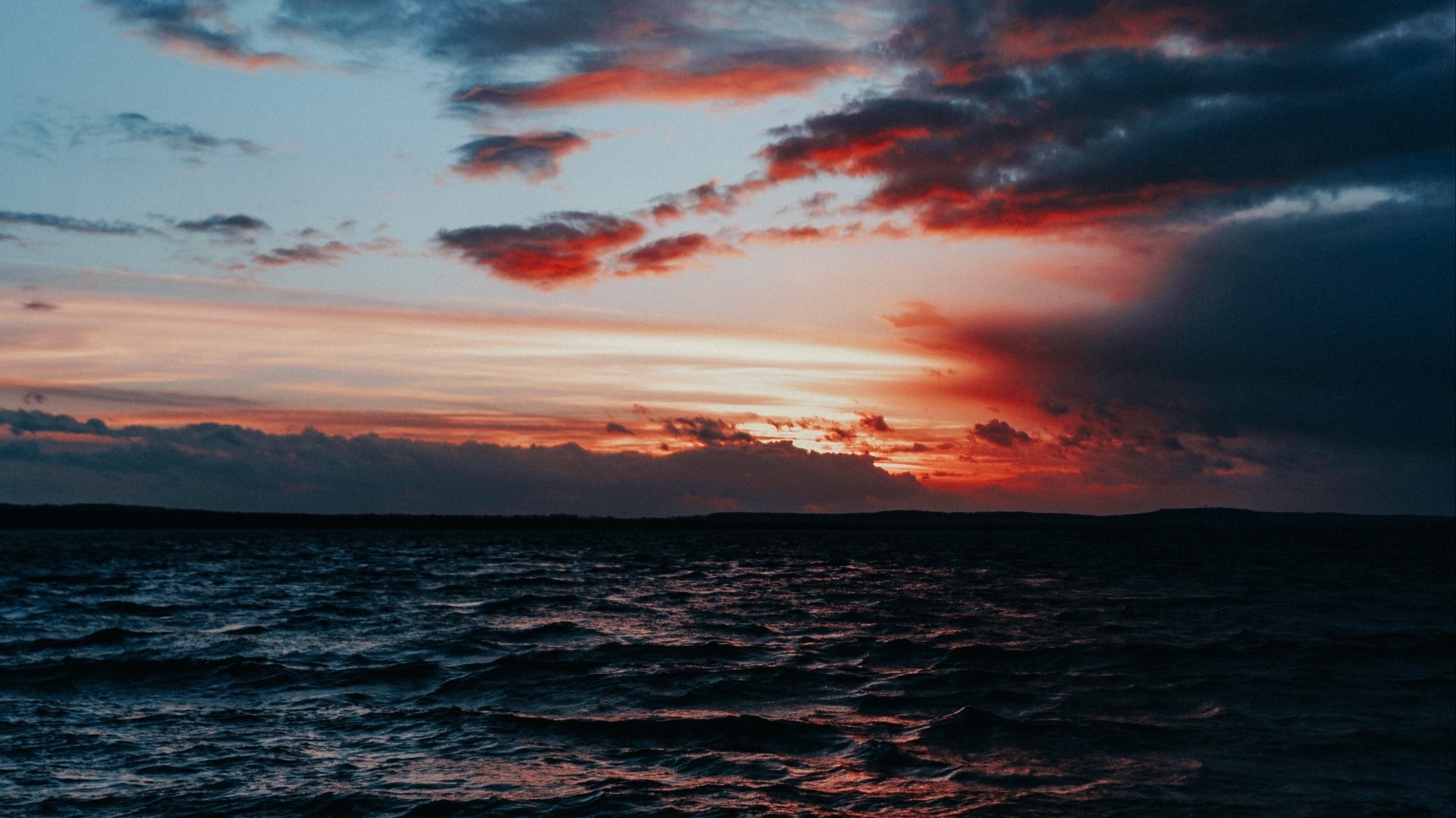 Sunset over the ocean with dramatic clouds HD Wallpaper