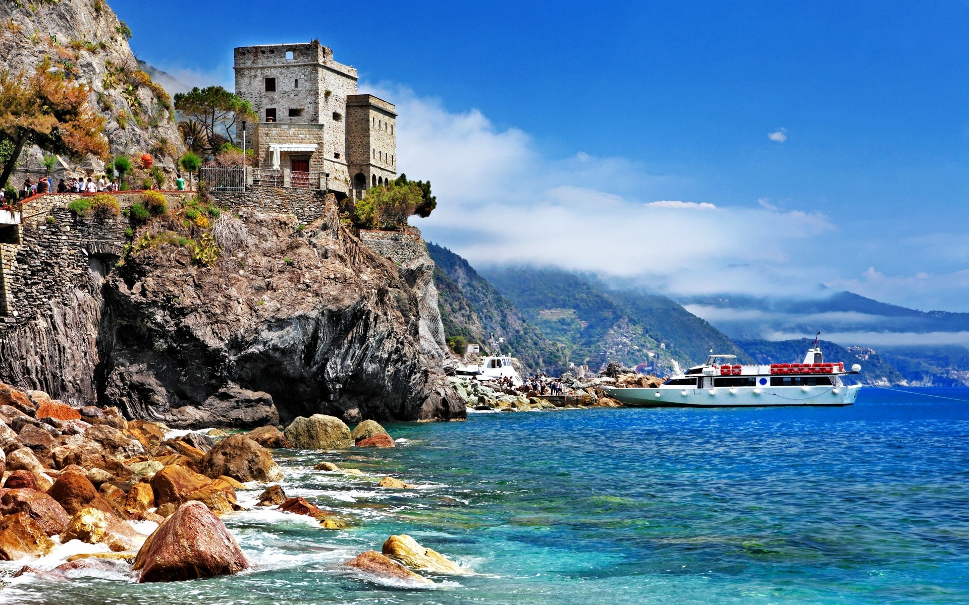 Castle on a cliff overlooking the sea with a boat HD Wallpaper