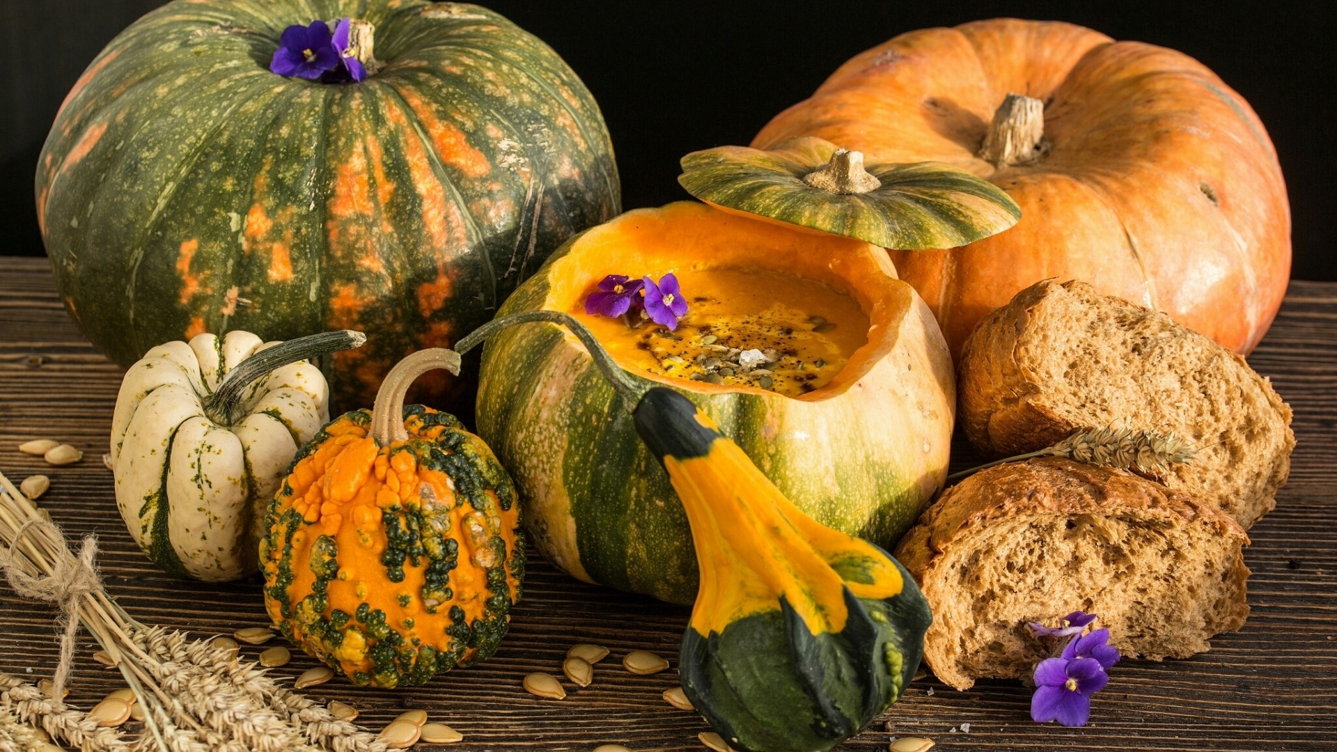 Assortment of pumpkins and bread on a wooden table HD Wallpaper