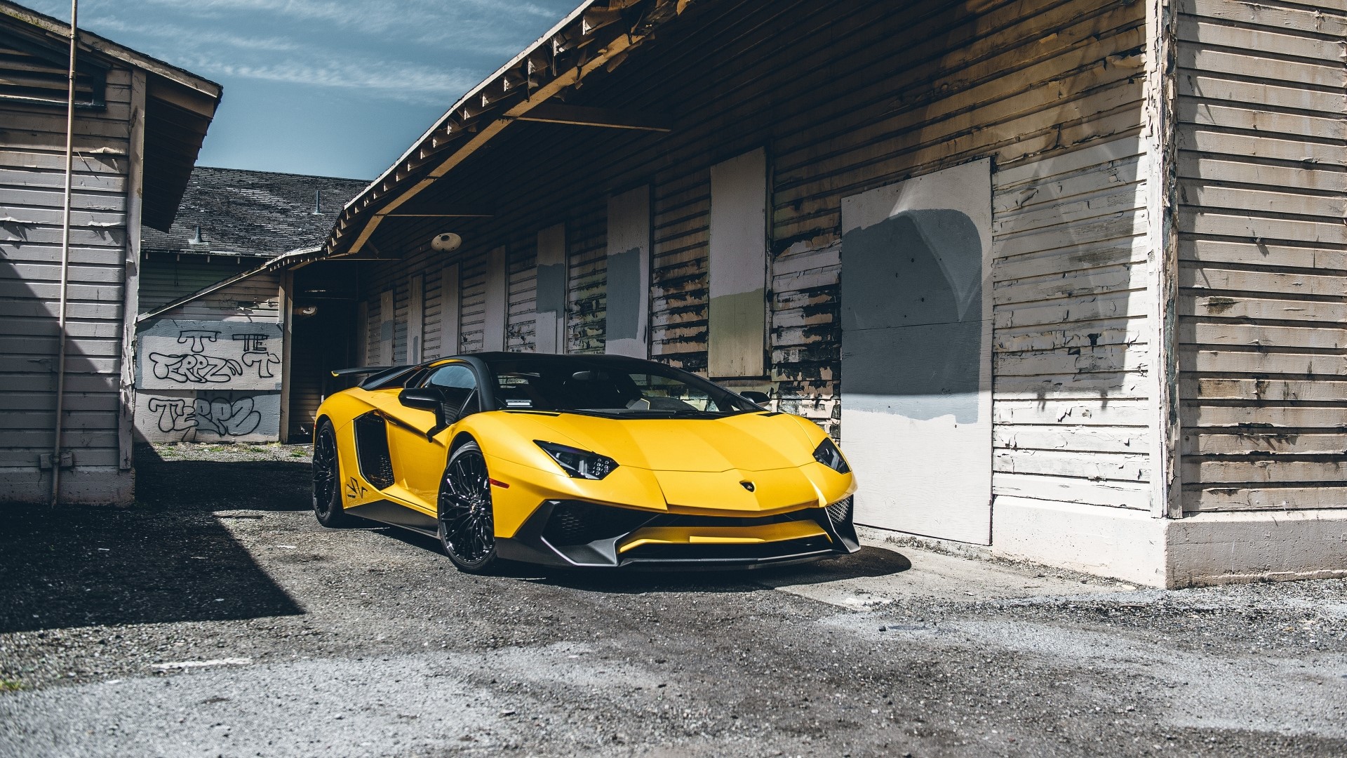 Yellow Lamborghini Aventador parked near old buildings HD Wallpaper